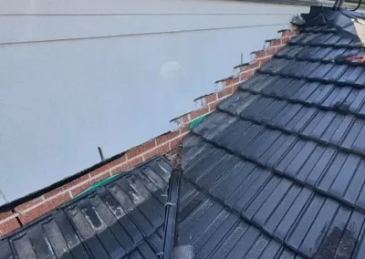 Roof restoration and flashing work along a tiled roof edge