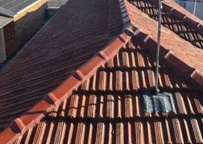 Roof restoration work underway around a tiled roof ridge