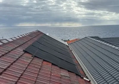 Residential roof restoration showing restored tile and metal roof sections