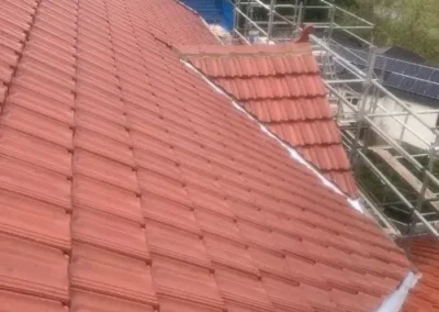 Restored red tiled roof showing clean roof lines and ridge capping