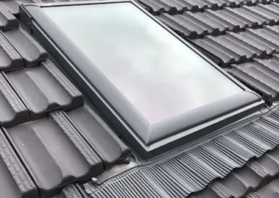 Low-profile skylight installed within a tiled roof