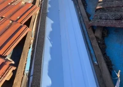Replacement roof valley flashing installed between terracotta tiles