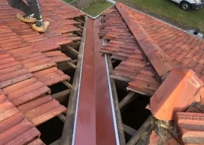 New metal valley flashing installed between tiled roof sections